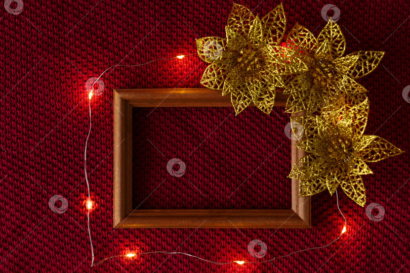 Скачать Рождественский фон. Рождественские игрушки, рамка и гирлянда на трикотажной основе свитера. фотосток Ozero