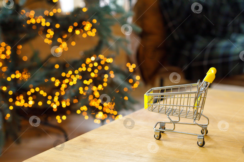 Скачать тележка с продуктами на столе на фоне гирлянд в стиле боке фотосток Ozero