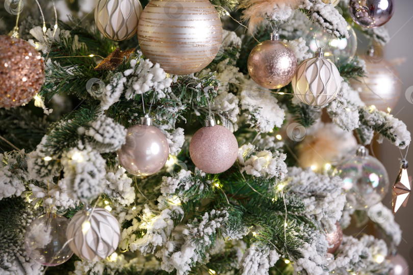 Скачать Белая рождественская игрушка, висящая на зеленой заснеженной еловой ветке фотосток Ozero