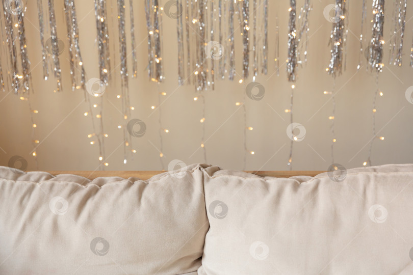 Скачать Диван и подушки украшены мишурой и гирляндами. Новогодний или рождественский фон фотосток Ozero