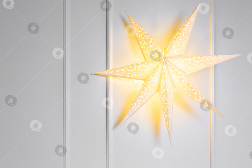 Скачать Объемная светящаяся звезда на белой стене. Новогодний или рождественский фон. Открытки и поздравительные открытки фотосток Ozero