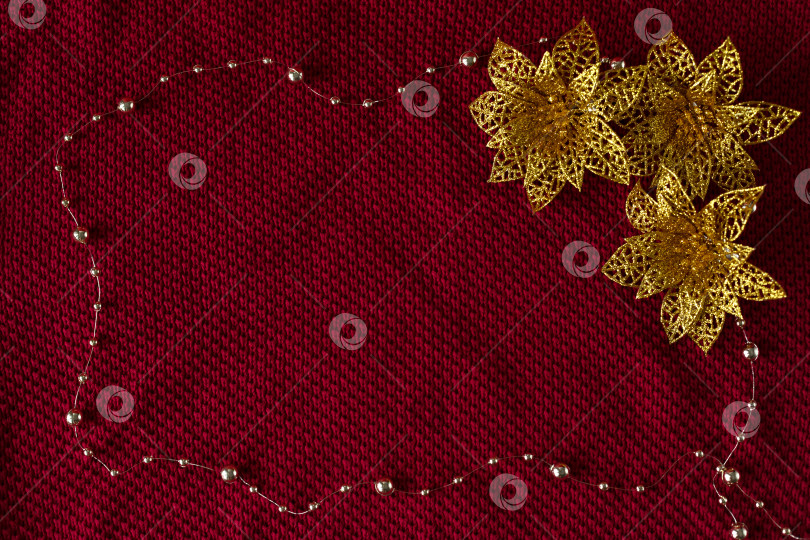 Скачать Рождественский фон. Рождественские игрушки и бусины расположены в виде рамки на трикотажной ткани свитера. фотосток Ozero