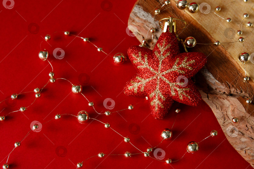 Скачать Рождественский фон. Бусины и игрушка на красном фоне и деревянной доске. фотосток Ozero