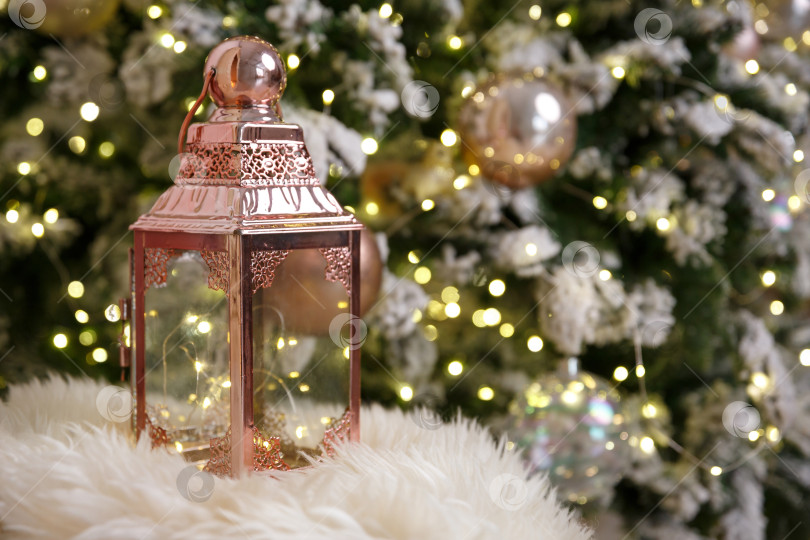 Скачать Розовый фонарь стоит на меховом пледе на фоне гирлянд огней фотосток Ozero