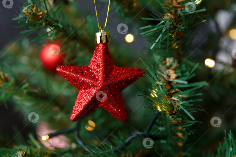 Скачать Новогодняя игрушка в виде звезды, висящая на ветке фотосток Ozero