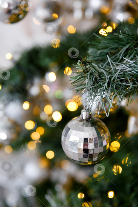 Скачать Рождественский игрушечный шар на ветке, на фоне боке-огней гирлянд фотосток Ozero