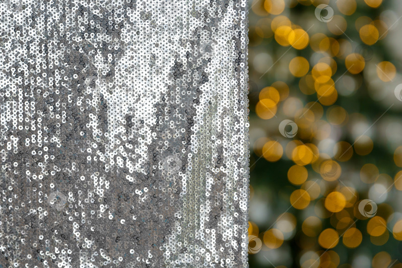 Скачать Рождественский и новогодний фон, материал, расшитый серебряными пайетками на фоне гирлянд огней фотосток Ozero