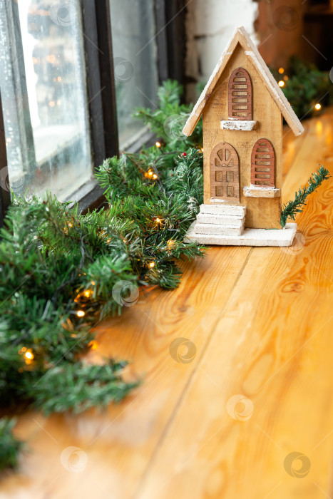 Скачать Новогодний и рождественский фон или поздравительная открытка. Игрушечный деревянный домик на подоконнике. Место для текста фотосток Ozero