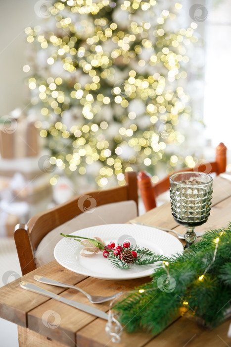 Скачать Сервировка стола с использованием посуды. Праздничное оформление еловыми ветками и гирляндами фотосток Ozero