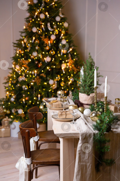 Скачать Праздничный деревянный обеденный стол украшен еловой гирляндой и белыми свечами фотосток Ozero