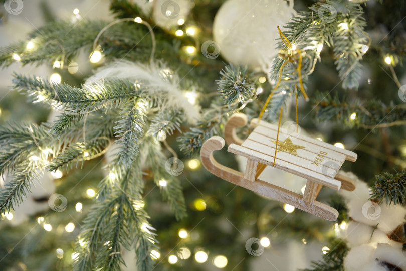 Скачать Новогодние игрушечные санки висят на ветке ели фотосток Ozero