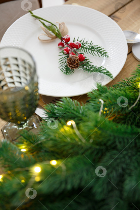 Скачать Сервировка стола с использованием посуды. Праздничное оформление. Еловые ветки и гирлянды фотосток Ozero