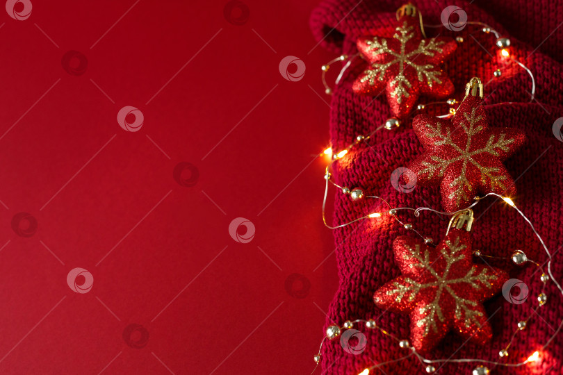 Скачать Рождественский фон с елочными игрушками, бусинами и гирляндой на трикотажном полотне. фотосток Ozero
