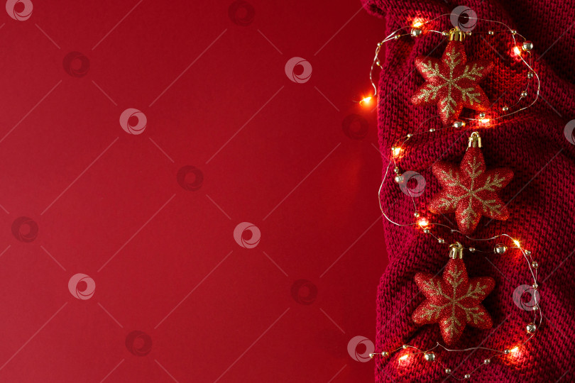 Скачать Рождественский фон с елочными игрушками, бусинами и гирляндой на трикотажном полотне. фотосток Ozero