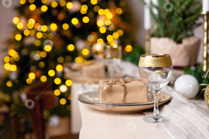 Скачать Праздничная сервировка стола на Рождество или Новый год. Бокал шампанского на столе. фотосток Ozero