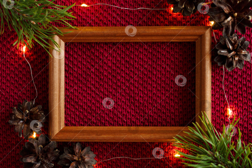 Скачать Рождественский фон. Шишки, рамка и гирлянда на трикотажной основе свитера. фотосток Ozero