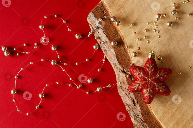 Скачать Рождественский фон. Бусины и игрушка на красном фоне и деревянной доске. фотосток Ozero