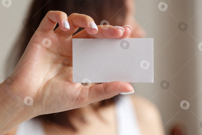 Скачать Мужчина держит в руке белую визитную карточку фотосток Ozero
