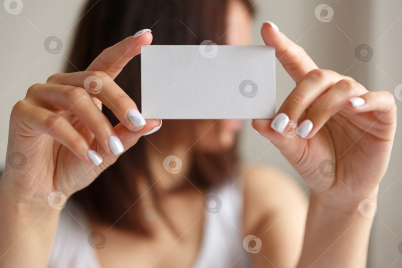 Скачать Мужчина держит в руке белую визитную карточку фотосток Ozero