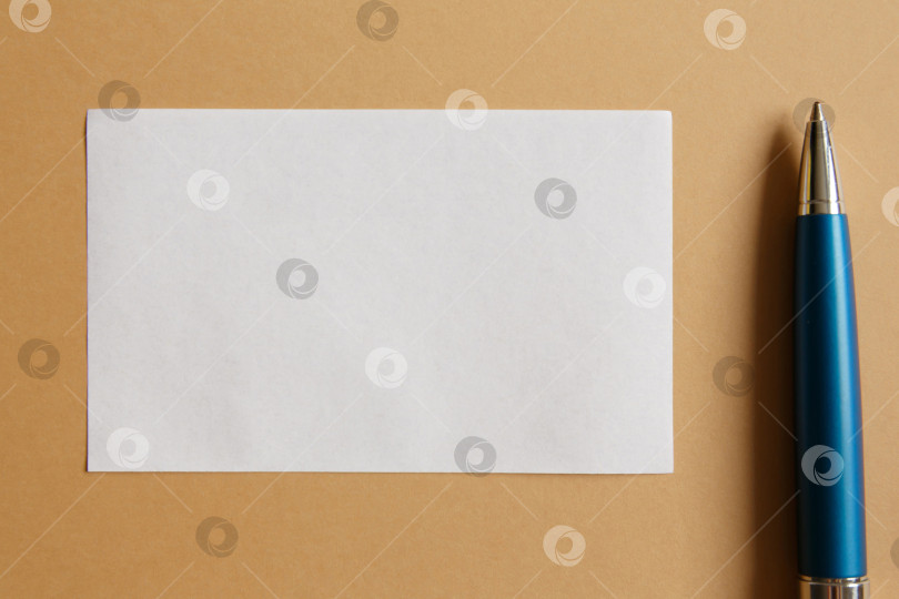 Скачать Маленький белый лист бумаги на коричневом фоне и ручка фотосток Ozero