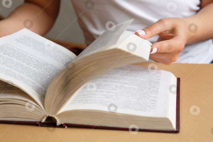 Скачать Женщина читает книгу. В руках она держит книгу. Красивый маникюр фотосток Ozero