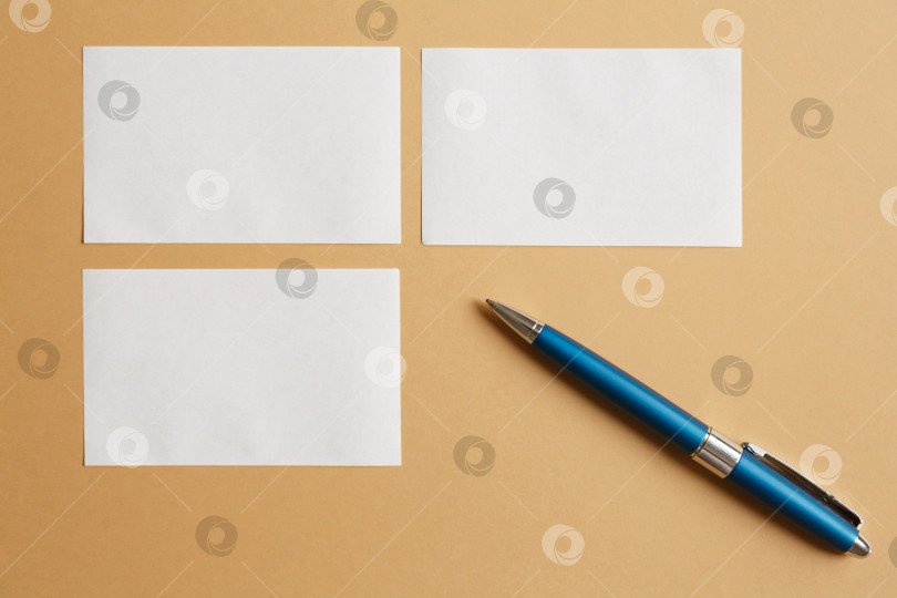Скачать Маленькие белые листы бумаги на коричневом фоне и ручка фотосток Ozero
