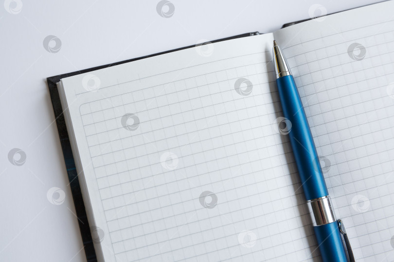 Скачать Ручка лежит на белом листе блокнота фотосток Ozero