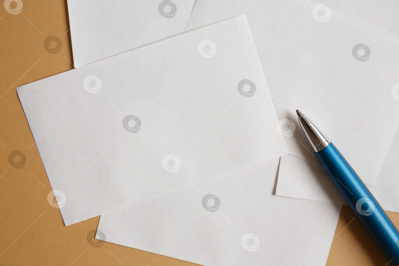 Скачать Маленькие белые листы бумаги на коричневом фоне и ручка фотосток Ozero