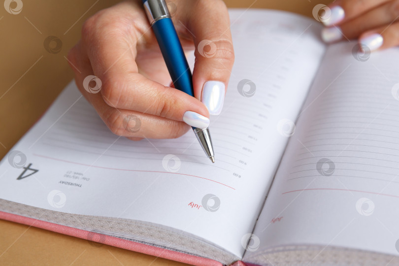 Скачать Мужчина пишет металлической ручкой в дневнике фотосток Ozero