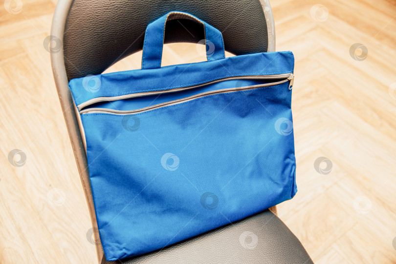 Скачать Синий рюкзак-Сумка-аксессуар для школьника-студента, Лежащего На Черном Стуле фотосток Ozero