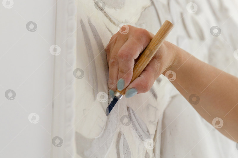 Скачать женская рука за работой, вырезает инструментом барельефный узор фотосток Ozero