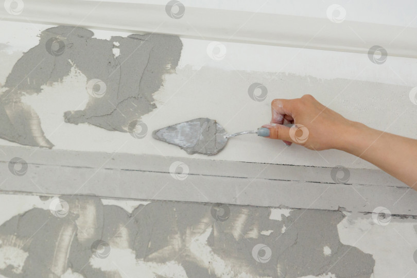 Скачать работница наносит на стену шпаклевочный раствор фотосток Ozero