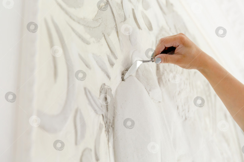 Скачать работница наносит шпаклевочный раствор на стену с барельефом фотосток Ozero