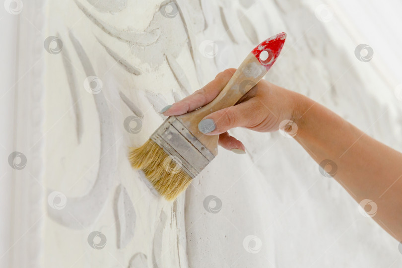 Скачать женская рука за работой, смахивающая кисточкой пыль с барельефа фотосток Ozero