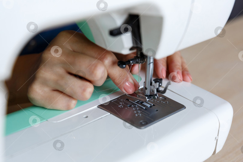 Скачать Рабочий процесс. Швея вдевает нитку в иголку фотосток Ozero