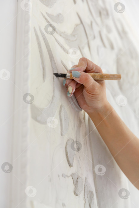 Скачать Рабочий процесс: женская рука резцом вырезает барельефный узор фотосток Ozero