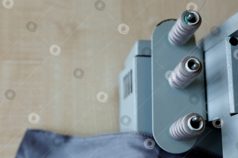 Скачать Натюрморт. Принадлежности для шитья. Нитки для оверлока и серая ткань фотосток Ozero