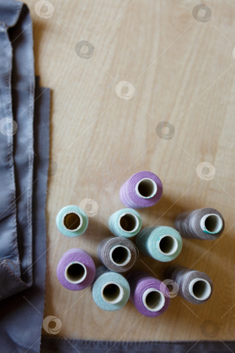 Скачать Натюрморт. Принадлежности для шитья. Нитки и ткань на деревянном столе фотосток Ozero