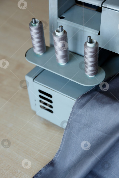 Скачать Натюрморт. Принадлежности для шитья. Нитки для оверлока и серая ткань фотосток Ozero