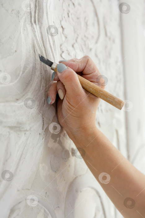 Скачать Рабочий процесс: женская рука резцом вырезает барельефный узор фотосток Ozero