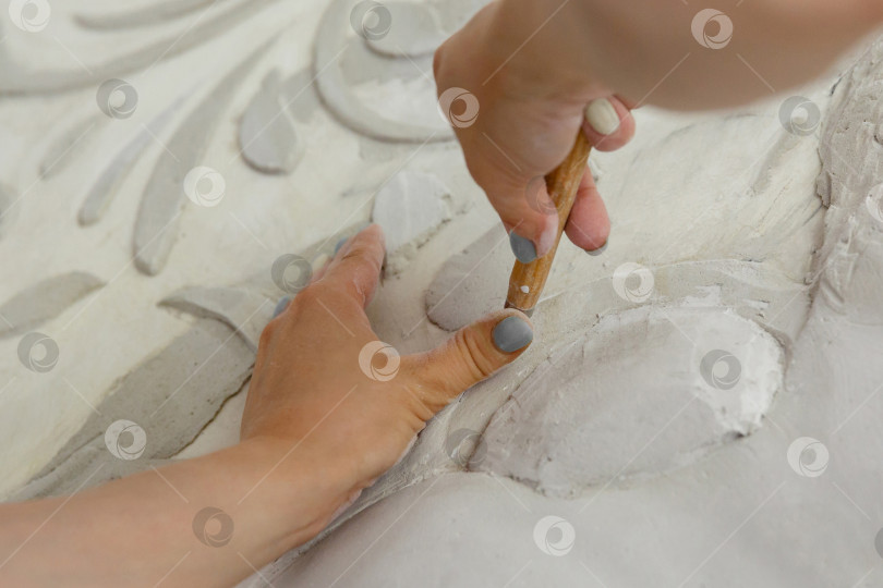 Скачать женские руки за работой, вырезают инструментом барельефный узор фотосток Ozero