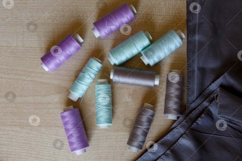 Скачать Натюрморт. Принадлежности для шитья. Нитки и ткань на деревянном столе фотосток Ozero