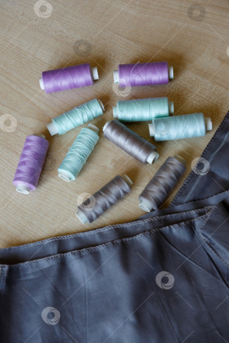 Скачать Натюрморт. Принадлежности для шитья. Нитки и ткань на деревянном столе фотосток Ozero