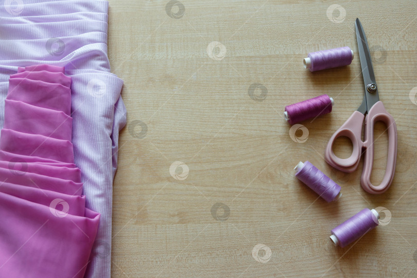 Скачать Натюрморт. Принадлежности для шитья. Ножницы, нитки и ткань на деревянном столе фотосток Ozero