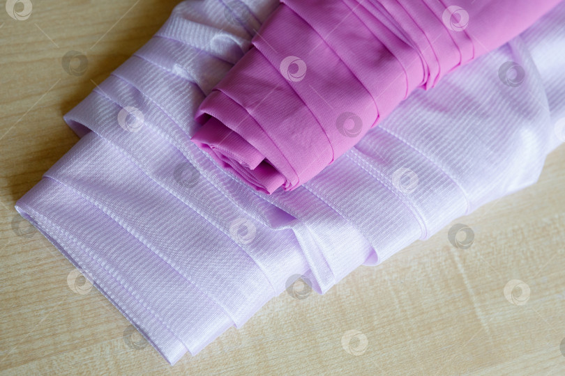 Скачать на деревянном столе лежат два рулона ткани фотосток Ozero