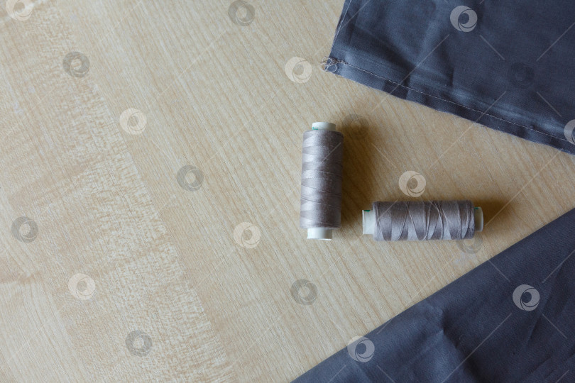 Скачать Натюрморт. Принадлежности для шитья. Нитки и ткань на деревянном столе фотосток Ozero