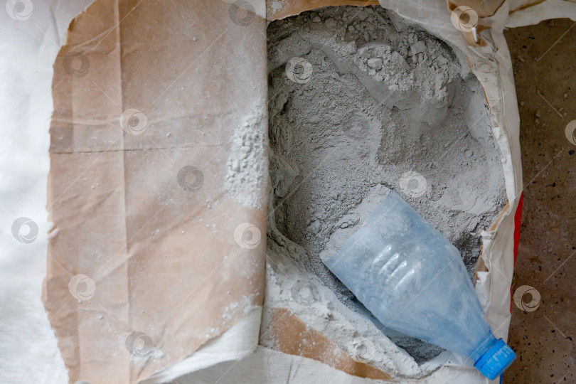 Скачать сухая порошкообразная строительная смесь серого цвета в картонном пакете фотосток Ozero