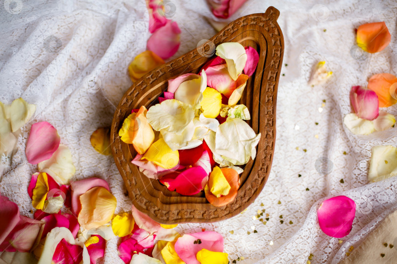 Скачать деревянная ваза с разноцветными лепестками роз на белом фоне фотосток Ozero