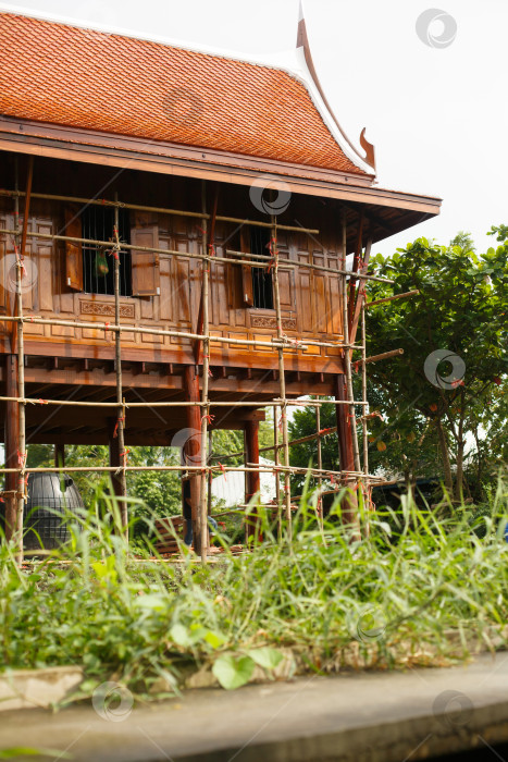 Скачать Деревянный дом на сваях у реки в Азии фотосток Ozero