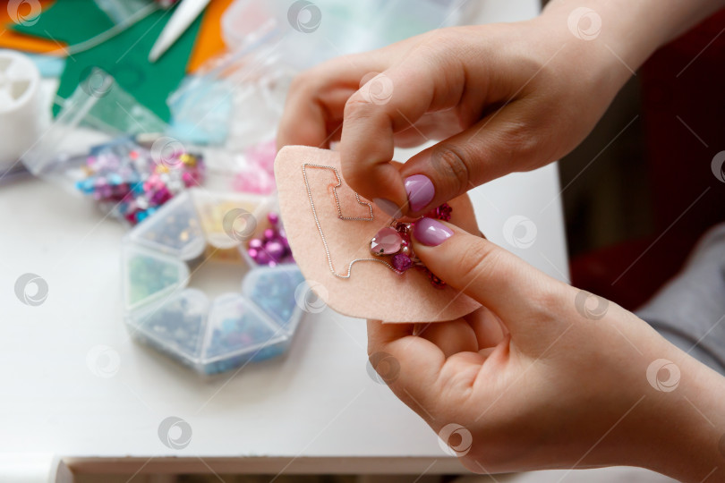 Скачать руками женщина мастерит брошь из бисера и кристаллов фотосток Ozero